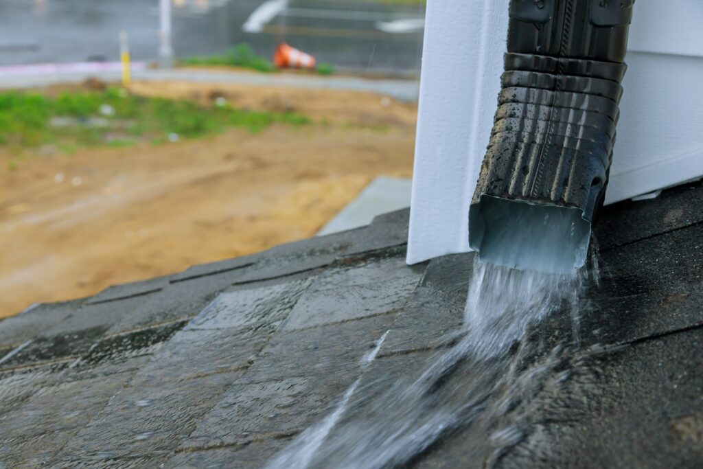 Heavy rain fall flowing out of gutter spout