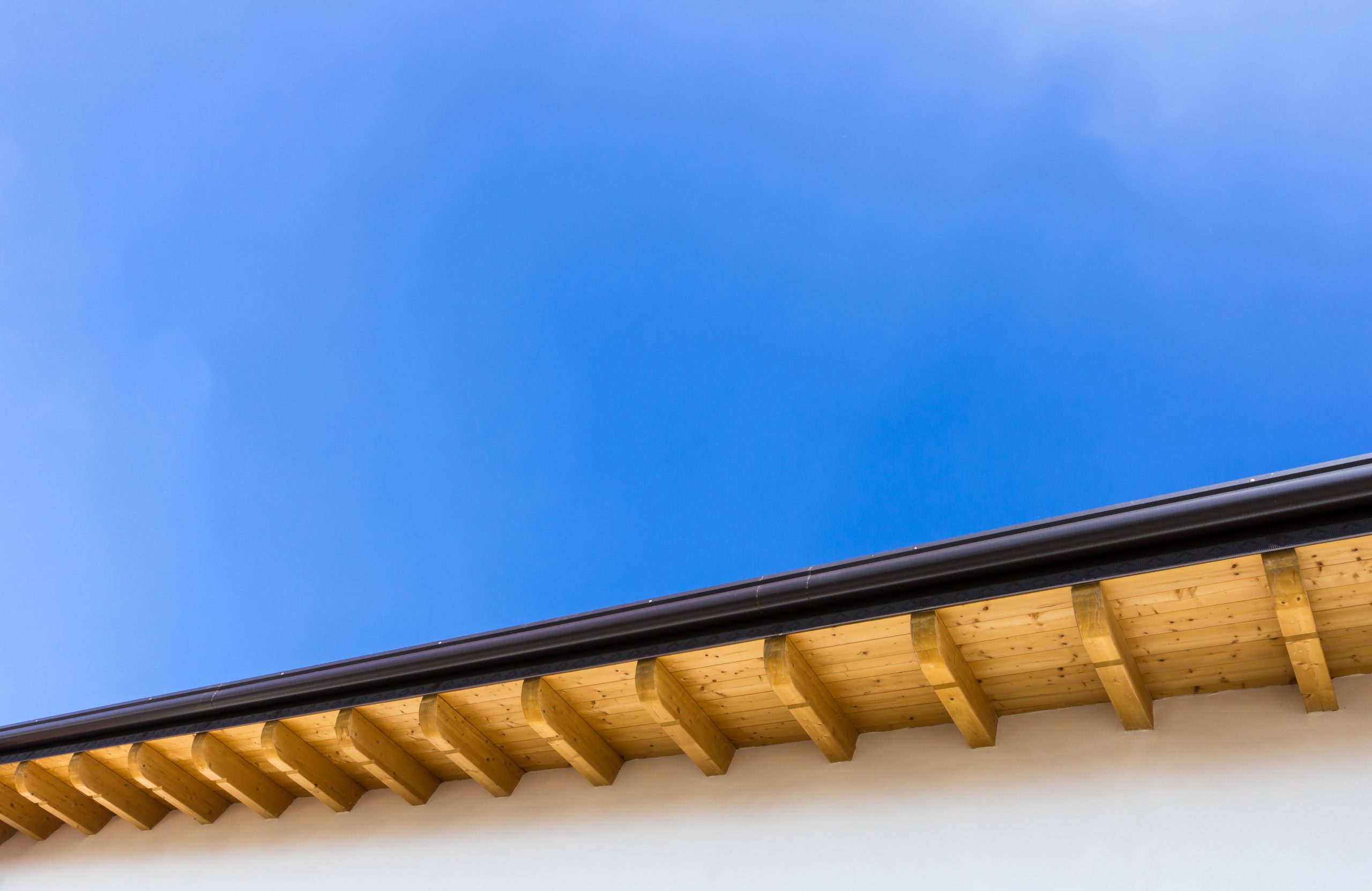 Underside of gutters against a blue sky