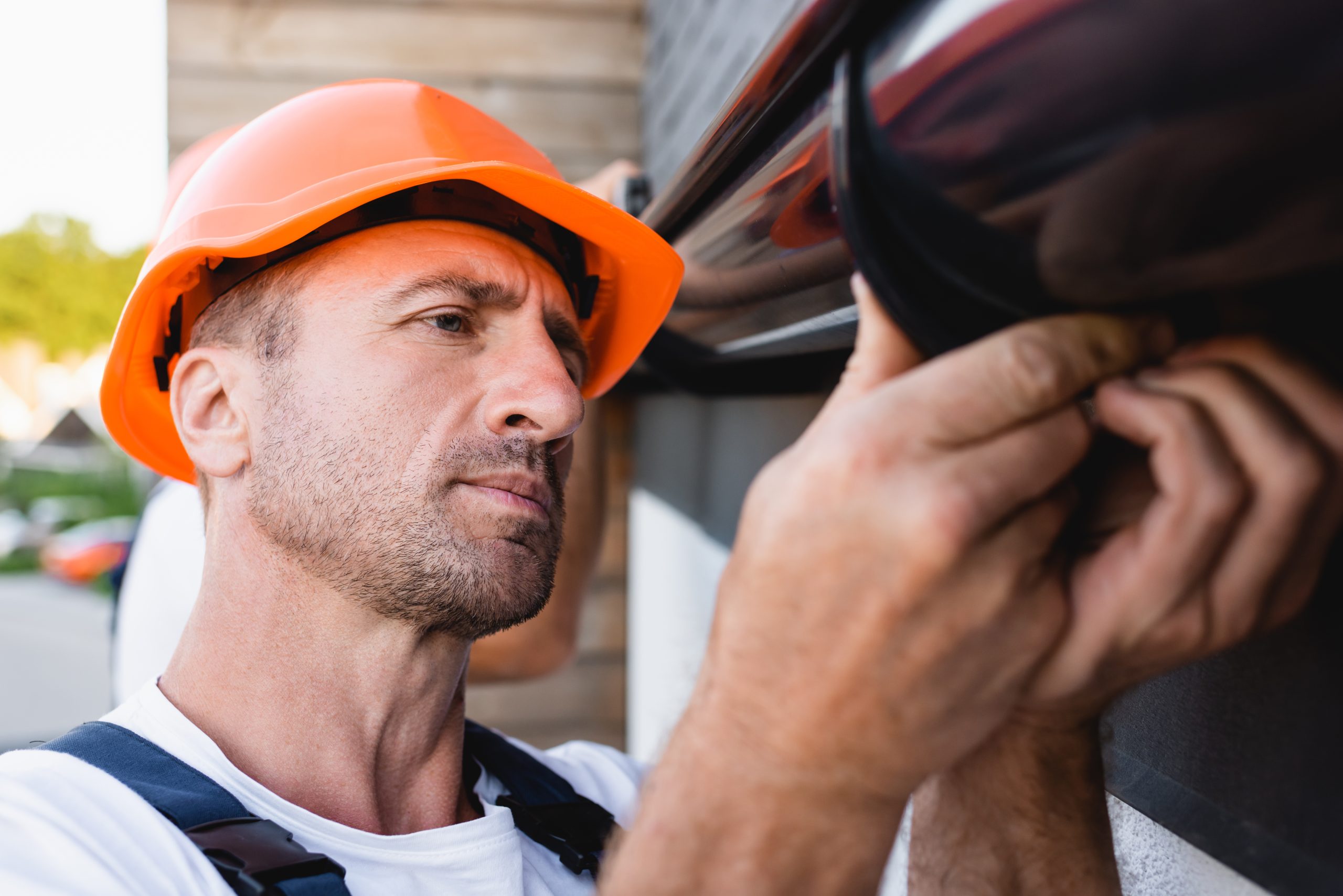 Man with an orange helmet installing gutters